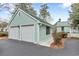 Spacious two-car garage featuring a matching green metal roof and adjacent paved driveway at 4413 Bed Straw Ct., Murrells Inlet, SC 29576