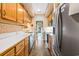 Galley kitchen with stainless steel appliances, light wood cabinets, and views to the backyard at 4413 Bed Straw Ct., Murrells Inlet, SC 29576