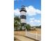 Picturesque lighthouse view surrounded by lush greenery, white picket fence and tranquil scenery at 4515 Lighthouse Dr. # 25B, Little River, SC 29566