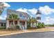 Inviting two-story home beside a lighthouse, adorned with palm trees and classic architectural details at 4515 Lighthouse Dr. # 25B, Little River, SC 29566