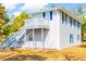 Two-story home featuring blue shutters and a wooden staircase leading to a porch at 4601 Lewis St., North Myrtle Beach, SC 29582