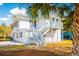 Two-story home with blue shutters and a wooden staircase leading to a porch at 4601 Lewis St., North Myrtle Beach, SC 29582