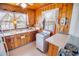 Charming kitchen featuring wood-paneled walls, a white oven, and natural light from the window at 4601 Lewis St., North Myrtle Beach, SC 29582