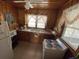 Cozy kitchen features wood paneled walls, white appliances, and a window providing natural light at 4601 Lewis St., North Myrtle Beach, SC 29582