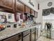 Kitchen boasts granite countertops, stainless steel sink, and dark wood cabinets at 4905 Britewater Ct. # 202, Myrtle Beach, SC 29579