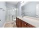 Bathroom featuring a glass-enclosed shower, vanity with wooden cabinets, and neutral tile flooring at 5230 Piemonte Ln., Myrtle Beach, SC 29579