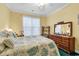 Bright bedroom features a full-size bed with a floral comforter, ceiling fan, and natural light at 537 Sand Ridge Rd., Conway, SC 29526