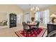 Traditional dining room boasts a chandelier, a black china cabinet, and a red rug under a round wooden table at 537 Sand Ridge Rd., Conway, SC 29526