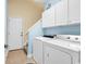 Bright laundry room with washer, dryer, cabinets, and a door to the exterior at 537 Sand Ridge Rd., Conway, SC 29526