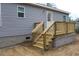 Wooden stairs leading to a back door, enhanced by a wooden handrail and gray siding on the house at 5810 Hwy 9, Nichols, SC 29581