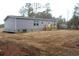 Side exterior view of the house, showing a deck with wooden stairs and gray siding at 5810 Hwy 9, Nichols, SC 29581