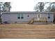 The side of the house is covered in gray siding, highlighted by an exterior deck with natural wood stairs at 5810 Hwy 9, Nichols, SC 29581