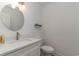 Bright half bath featuring a sleek vanity with a modern sink and round mirror at 5811 Sumter Dr., Myrtle Beach, SC 29577