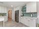 Bright kitchen with white cabinetry, stainless steel appliances, and glass display shelves, seamlessly connecting to adjacent rooms at 5811 Sumter Dr., Myrtle Beach, SC 29577