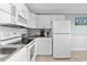 Functional kitchen featuring white cabinets and appliances, with tile floors at 5905 S Kings Hwy. # 327 A, Myrtle Beach, SC 29575