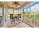 Relaxing screened-in porch with comfortable seating, ceiling fan, and a view of the lush surroundings at 65 Lakeside Dr. # 65A, Pawleys Island, SC 29585