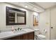 Bathroom with dark vanity, framed mirror, and toilet with a white countertop at 705 11Th Ave. S, North Myrtle Beach, SC 29582