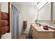 Bright bathroom featuring a vanity with marble countertop, a shower with blue curtain, and a towel rack at 705 11Th Ave. S, North Myrtle Beach, SC 29582