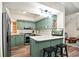 Well-lit kitchen featuring stainless steel appliances, a breakfast bar, and attractive green cabinetry at 705 11Th Ave. S, North Myrtle Beach, SC 29582