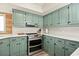 Stylish kitchen with teal cabinets, stainless steel appliances and white countertops at 705 11Th Ave. S, North Myrtle Beach, SC 29582