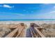 A wooden walkway to the beach on a sunny day with blue skies and ocean views at 709 Shell Creek Circle # 709, North Myrtle Beach, SC 29582