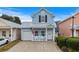 Charming light blue two-story home featuring a cozy front porch and an attached single-car garage at 709 Shell Creek Circle # 709, North Myrtle Beach, SC 29582