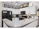 Open kitchen design with crisp white cabinets and black appliances and stone countertops at 759 Painted Bunting Ct. # A, Murrells Inlet, SC 29576