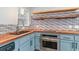 Close-up view of a kitchen featuring butcher block counters, stainless steel appliances, and blue cabinets at 9545 Sullivan Dr., Murrells Inlet, SC 29576