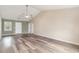 Open-concept living room with gray-toned wood floors, a window, and high ceilings at 9545 Sullivan Dr., Murrells Inlet, SC 29576