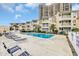 Outdoor pool with lounge chairs and palm trees surrounded by multi-story condos at 9620 Shore Dr. # C101, Myrtle Beach, SC 29572