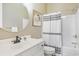 Bathroom featuring modern round mirror, white vanity, and striped shower curtain at 10 Orchard Ave., Murrells Inlet, SC 29576