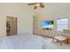 Bright bedroom featuring a ceiling fan and TV with tropical beach scene at 10 Orchard Ave., Murrells Inlet, SC 29576