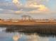 Marshy landscape under a cloudy sky; community beyond, reflected in serene waters at 10 Orchard Ave., Murrells Inlet, SC 29576