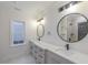 Bright bathroom with dual sinks, quartz counters, sleek black hardware, and decorative mirrors at 1054 East Isle Of Palms Ave., Myrtle Beach, SC 29579