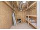 Unfinished storage room with exposed wooden studs and rafters, and a single light overhead at 1054 East Isle Of Palms Ave., Myrtle Beach, SC 29579