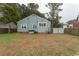 Back exterior view of the home with a large yard and a combination of grass and brown covered ground at 1105 Palmetto St., Georgetown, SC 29440