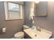 Gray-painted bathroom with standard white toilet, sink, mirror and window at 1105 Palmetto St., Georgetown, SC 29440