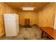 Interior view of a shed, with wood paneling, a refrigerator, table and a small chest of drawers at 1105 Palmetto St., Georgetown, SC 29440