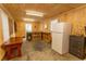 Interior view of a shed, with wood paneling, a refrigerator, table and storage cabinets at 1105 Palmetto St., Georgetown, SC 29440