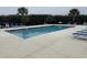 Community swimming pool surrounded by lounge chairs and greenery at 113 Butkus Dr. # 3, Myrtle Beach, SC 29588