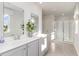 Bathroom with double sink vanity, large mirrors, and a walk-in shower with glass doors at 124 Shucking St., Myrtle Beach, SC 29588