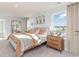 Sunlit bedroom boasts modern lighting and a view of the community pond through large windows at 124 Shucking St., Myrtle Beach, SC 29588