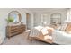 This bedroom showcases a rustic dresser, round mirror, and lots of natural light at 124 Shucking St., Myrtle Beach, SC 29588