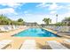 Community pool with lounge chairs is surrounded by palm trees with community buildings in the background at 131 Waypoint Ridge Ave. # Q-14, Little River, SC 29566