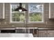 Close-up of a stainless steel farmhouse sink with a modern faucet and bright natural light at 1310 Rabbit Ln., Conway, SC 29526