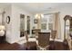 Cozy dining area features a glass-top table, wicker chairs, and natural light from the window and glass doors to the patio at 1442 Chanson Ct., Little River, SC 29566