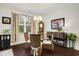 Dining room features hardwood floors, a decorative chandelier, and large windows at 1442 Chanson Ct., Little River, SC 29566