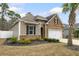 A charming home featuring a stone facade, manicured lawn with mulch beds, and complemented by a swaying palm tree at 1442 Chanson Ct., Little River, SC 29566