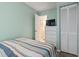 Cozy bedroom with a striped bedspread, white dresser, TV, and a door to the bathroom at 1709 S Ocean Blvd. # 411, North Myrtle Beach, SC 29582