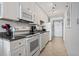 All white kitchen with tile floors and black countertops at 1709 S Ocean Blvd. # 411, North Myrtle Beach, SC 29582